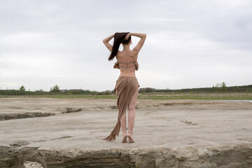 beautiful brunette girl in an amazon costume in the desert.