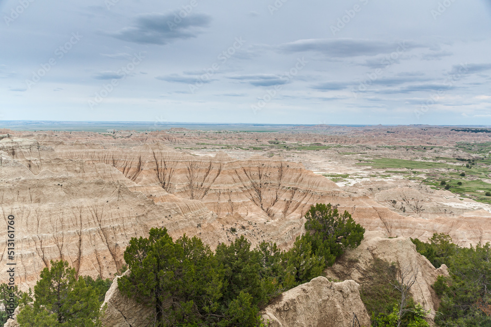 Sticker Colorful hills on the background of green field, under a blue sky in Badlands National Park, USA