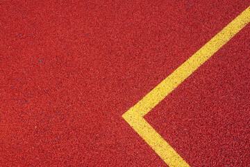 Colorful sports court background. Top view to red field rubber ground with yellow corner lines outdoors