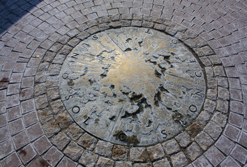Bronze sun on the ground near the monument to Nicholas Copernicus