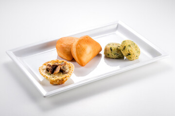 Rectangular plate with mini calzone, potato croquettes with tops, crispy pastry with porcini mushrooms