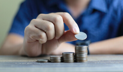 Close up of man's hand putting coin, for business investment or saving concept