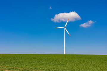 A wind turbine in front of blue sky on a clear day