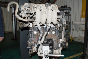 View from the intake manifold side of the assembled car engine installed on the engine repair stand