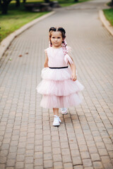 pretty little girl walking in the park - obrazy, fototapety, plakaty
