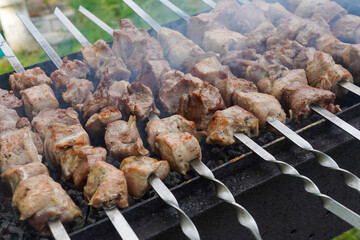Barbecue on skewers cooked on the grill with smoke