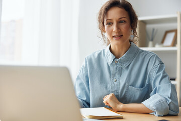 Candidate on vacant place answering question of hr in online meeting using laptop. Curly awesome cheerful attentive woman interested listens to employer about conditions of new job at video call