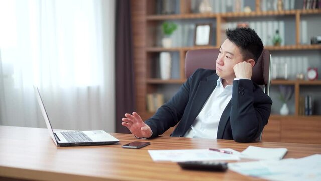 bored asian businessman sitting at computer desk working at workplace in office. Business man Banker manager, employee entrepreneur misses boredom without inspiration for desktop with laptop. indoor