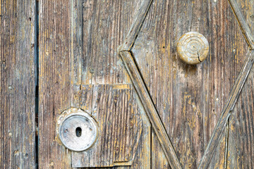 Dettaglio di serratura e maniglia di antica porta chiusa di vecchia chiesa. Porta di legno marrone corrosa dal tempo.