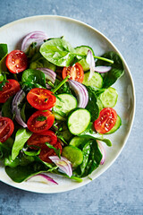 Tomato, spinach and cucumber salad with red onion and herbs	