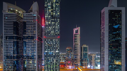 Fototapeta na wymiar Aerial view of Dubai International Financial District with many skyscrapers night timelapse.