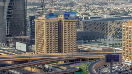 Big highway junction and Dubai water canal with pedestrian bridge over it aerial timelapse.