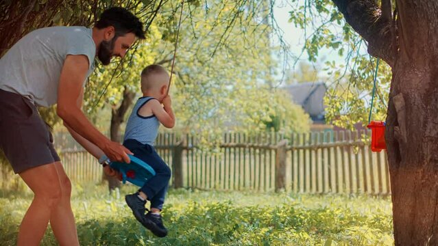 Cute Little Kid Having Fun. Carefree Preschool Son Enjoy Activity. Children Playing Family Parent Holidays Relationship With Kid Swing Ride. Happy Family Child Game Boy Leisure. Son Boy Play Happiness