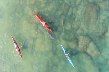 Drone view of kayaks sail in shallow water with sharks coming to shore due to the hot water of the powerhouse "Hadera Lights"