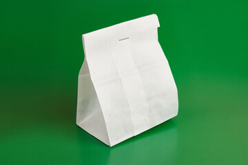Paper bag with tea. Packaging for dry products on a green background.