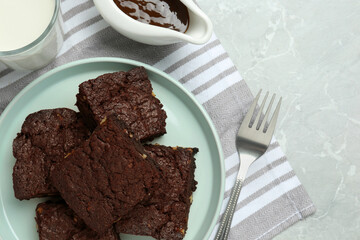 Delicious chocolate brownies with nuts on light grey table, flat lay