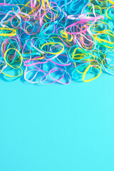Plastic rubber bands elastics on blue background. Minimal concept. Flat lay.