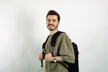 Cheerful young man wearing t-shirt posing isolated over white background posing education in high school university college concept.