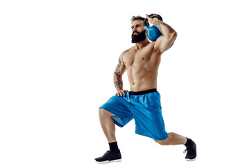 Muscular shirtless tattooed bearded male athlete bodybuilder workout with kettlebell on a white background. Isolate - obrazy, fototapety, plakaty