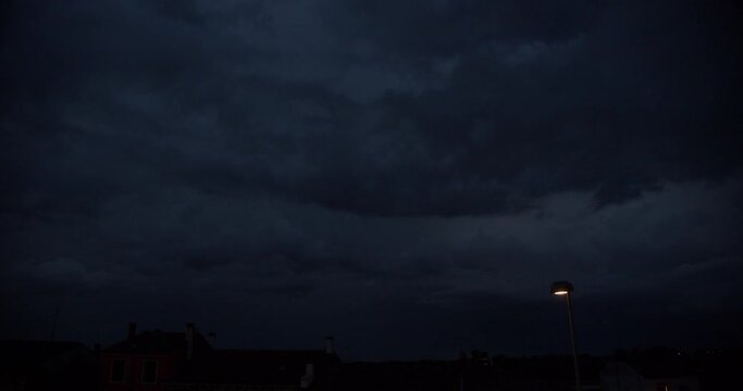 Intense thunderstorm with lightning in the clouds. Night sky just after a strong summer storm in Italy. Natural disasters and climate change.