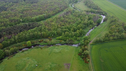 drone shot lush landscape horses and farmhouse