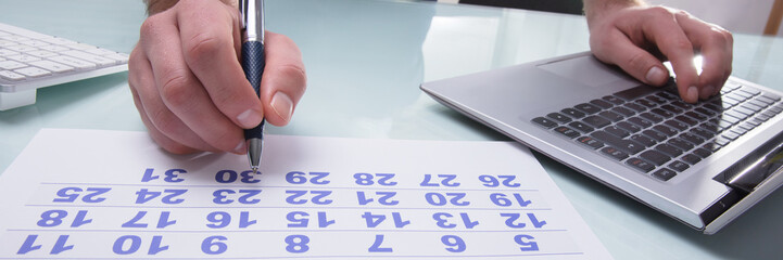 Businessperson Marking With Pen On Calendar