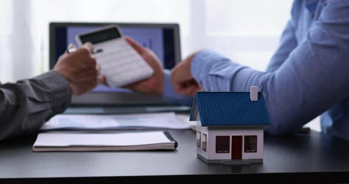 Real estate broker agent presenting and consult to customer to decision making sign insurance form agreement, buy and sell home model, concerning mortgage loan offer for and house insurance