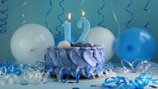 Happy twelfth birthday navy cake and number twelve candle with blue balloons and decoration, anniversary celebration