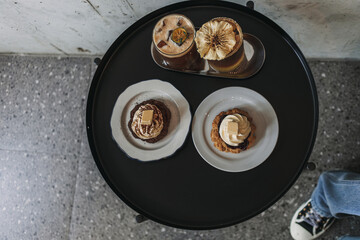 Dessert set of scones and americano coffee for couple served in cafe.