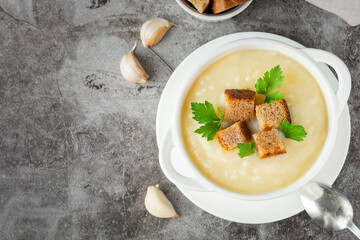 Cauliflower potato soup puree on stone background, Creamy cauliflower soup with toasted bread croutons.Vegetarian healthy food concept. Ideas and recipes for winter meal - obrazy, fototapety, plakaty