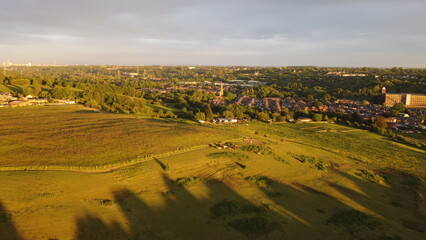Fototapeta na wymiar sunset city and horse view. drone shooting in green countryside