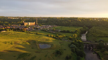 Fototapeta premium sunset city and horse view. drone shooting in green countryside