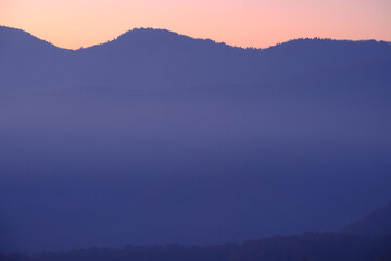 subtle purple and orange sunrise hues in a simple mountain landscape