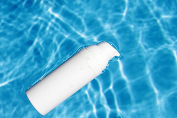 White cosmetic tubes on the water surface. Blank label for branding mock-up. Summer vacation cosmetics concept. Flat lay. Copy space.