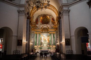 interior of a beautiful catholic church with benches icons and chandeliers