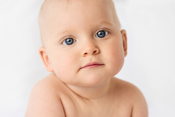 Close-up portrait of serious baby girl with blue eyes