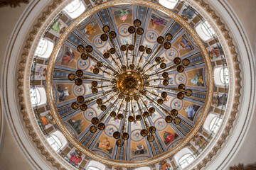 Fototapeta na wymiar beautiful chandelier on a round painted ceiling in a catholic church