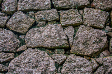 Stone antique old wall as a background or texture. Vintage background of a fortress wall in loft and grunge style with place for text and copy space.