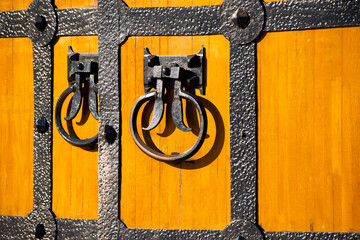 an old wooden gate with ring handles is ajar
