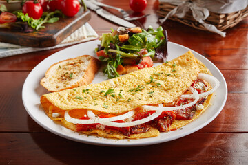 Greek Style cream sauce omelette roll with salad served in a dish isolated on wooden background side view