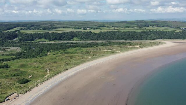 Oxwich Bay on the Gower peninsula in Swansea, UK, a long sweeping sandy bay with a shallow water line with easy access by road from Swansea attracts visitors from all over the UK