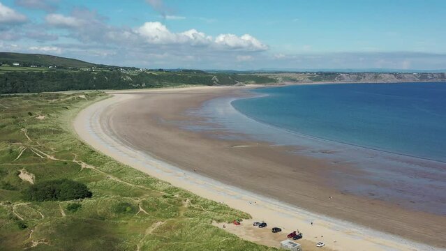 Oxwich Bay on the Gower peninsula in Swansea, UK, a long sweeping sandy bay with a shallow water line with easy access by road from Swansea attracts visitors from all over the UK