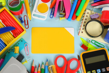 A lot of colorful stationery, in the center is an empty card template on a blue background.Purchases of office supplies online through online stores, discounts and promotions on school supplies