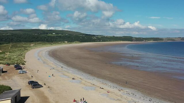 Oxwich Bay on the Gower peninsula in Swansea, UK, a long sweeping sandy bay with a shallow water line with easy access by road from Swansea attracts visitors from all over the UK