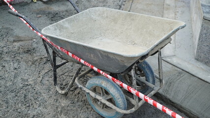 Old wheelbarrow for moving cement on construction site