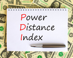 PDI power distance index symbol. Concept words PDI power distance index on white note on a beautiful background from dollar bills. Metallic pen. Business PDI power distance index concept. Copy space.