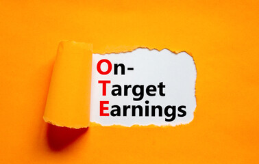 OTE on-target earnings symbol. Concept words OTE on-target earnings on white paper on a beautiful orange background. Business and OTE on-target earnings concept. Copy space.
