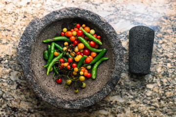 Top view of a molcajete with tomatoes and chilli pepper