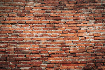 Red brick wall texture. Abstract brick wall background, wall of old, cracked bricks, with a weathered and faded surface.	