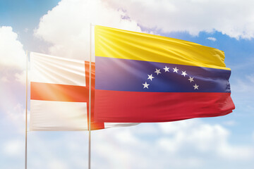 Sunny blue sky and flags of venezuela and england